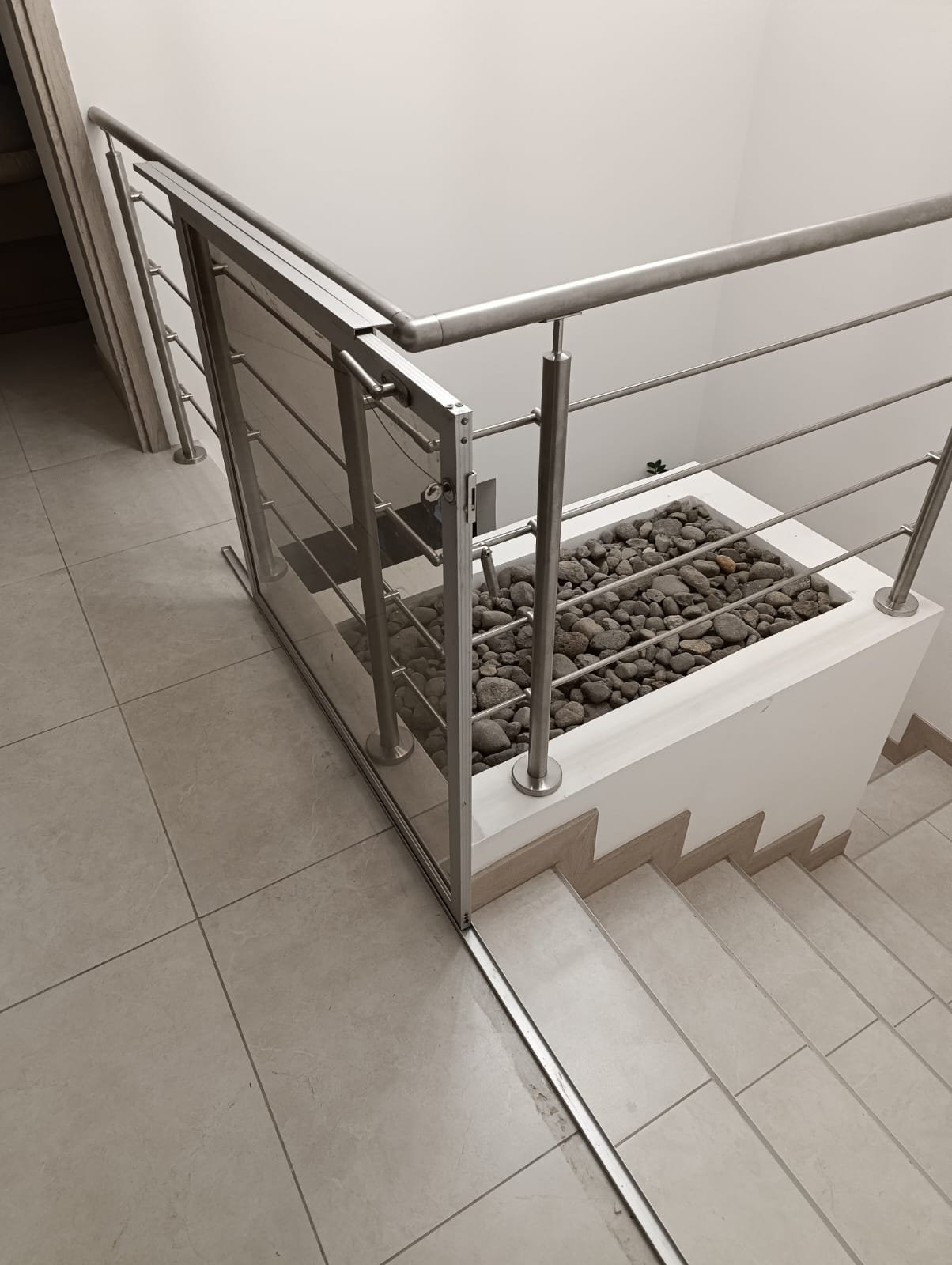 Baranda de acero inoxidable con paneles de vidrio fabricada a medida en escalera